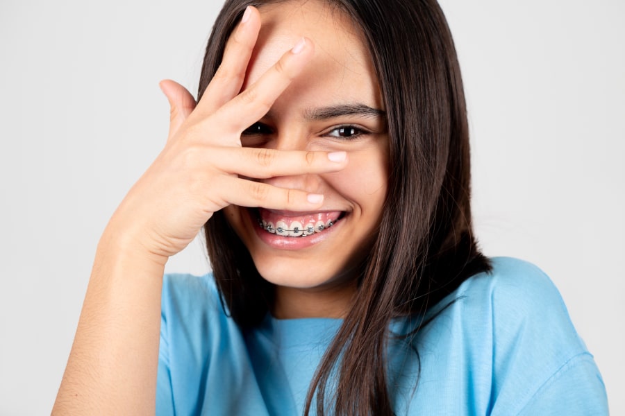 A girl with braces is smiling