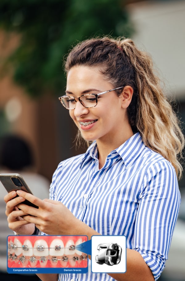 A woman is smiling and holding her phone