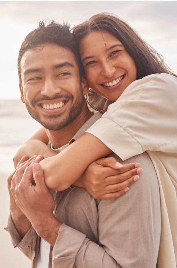 Straighten Your Smile at Any Age! Couple is hugging and smiling on the beach